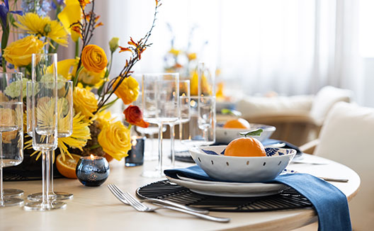 Wedding dining set-up with flowers and an orange in each bowl