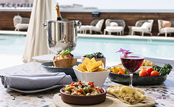 hummus, chips, champagne, cocktail, crudite, in a cabana by the pool