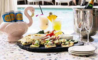 flatbread, champagne, cocktails, canned spritzers in a cabana by the pool