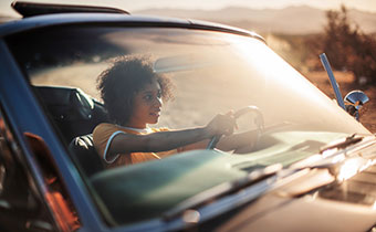 woman in drivers seat of a convertible car